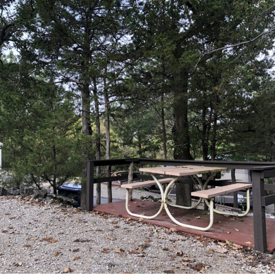 Picnic table and portable ﬁre pit at a campsite in Branson Shenanigans RV Park